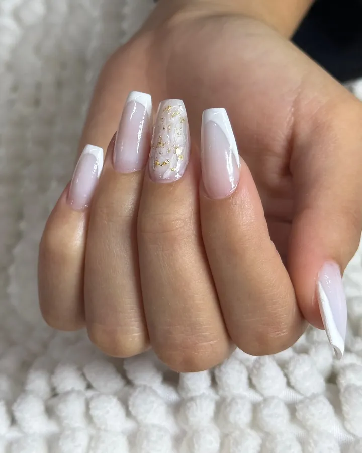Unhas longas brancas com uma unha decorada em dourado